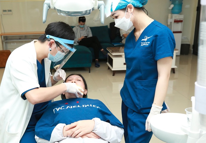 Bác sĩ thăm khám và điều trị bệnh lý răng miệng an toàn